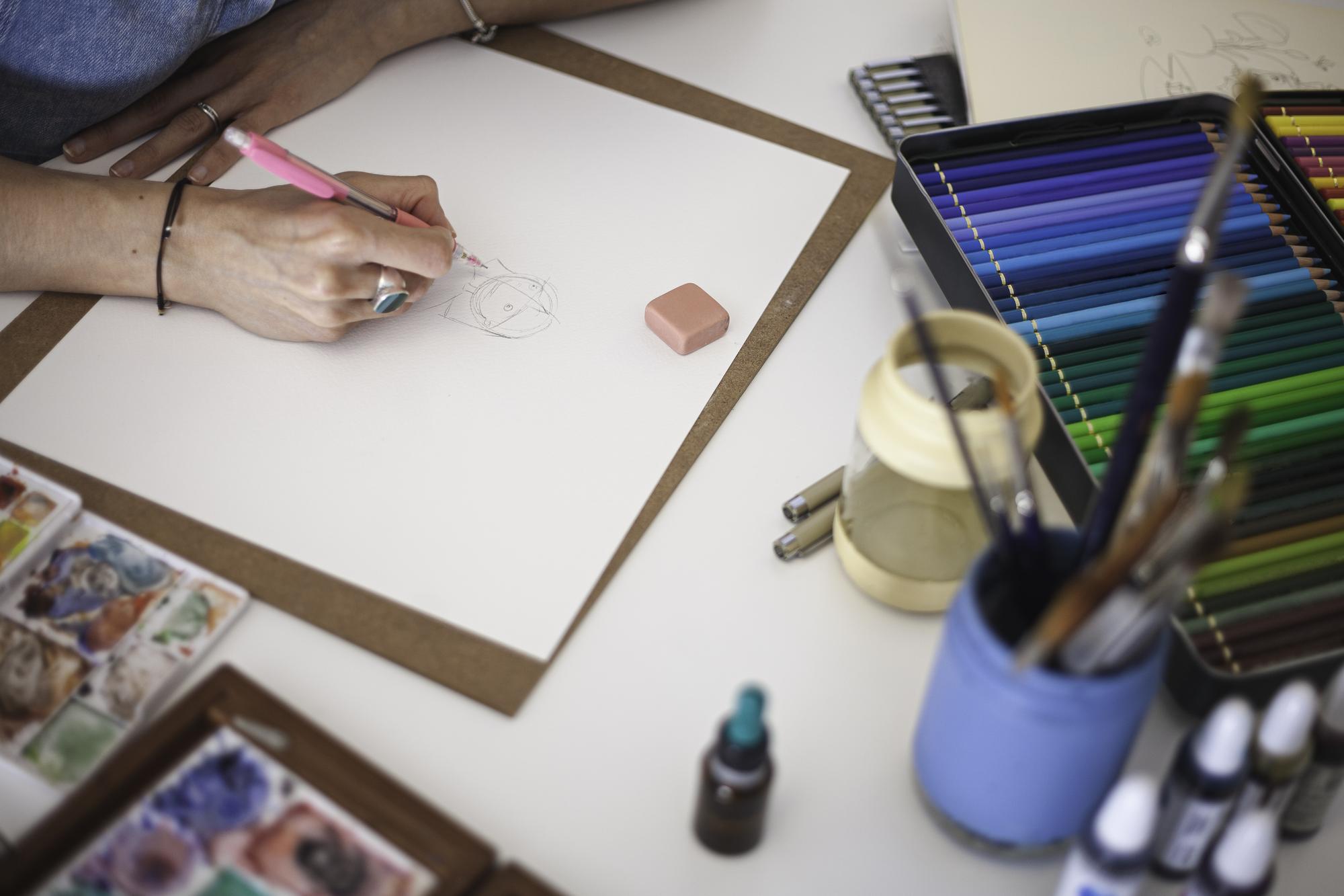 studio table with threads, sample swatches and sketches
